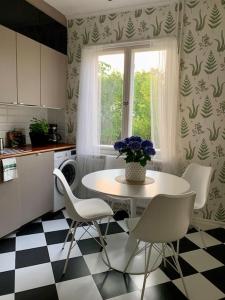 a kitchen with a table and chairs and a window at Smakfull centrumlägenhet, 3 r + k, 80 m2 in Mariehamn