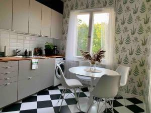 kuchnia ze stołem i krzesłami oraz oknem w obiekcie Smakfull centrumlägenhet, 3 r + k, 80 m2 w mieście Maarianhamina