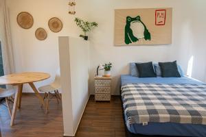 een kleine slaapkamer met een bed en een tafel bij MY - Cosy Lodges in Paraíso