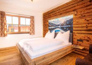 ein Schlafzimmer mit einem Bett mit einem großen Gemälde an der Wand in der Unterkunft Schitter-Appartements in Mauterndorf