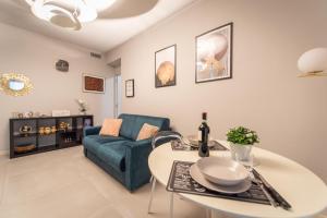 een woonkamer met een tafel en een blauwe bank bij Elegante Bilocale-Centro Torino-Free WiFi in Turijn