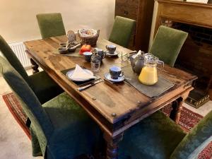 a wooden table with plates and utensils on it at Yew Tree House, Bed & Breakfast in Colchester in Lexden