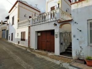 uma fila de edifícios brancos com portas castanhas numa rua em Casa Vacanze Gina e Umberto em Piano Conte