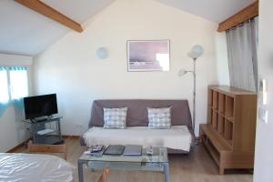 a living room with a bed and a couch at Meublé 2* climatisé dans un quartier calme in Dijon