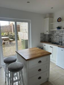 a kitchen with a counter and two stools at 4 Castle Court in Killyhevlin