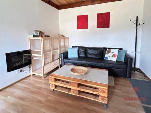 ein Wohnzimmer mit einem Sofa und einem Couchtisch in der Unterkunft Skarb Sołtysa - apartament z widokiem in Jedwabno