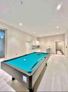 a pool table in a living room with a pool at Madinah Valley Residency Room 1 in Sulţānah