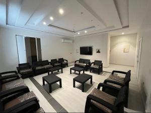 a waiting room with black chairs and a flat screen tv at Madinah Valley Residency Room 1 in Sulţānah