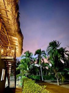 El Puertón的住宿－Cabaña CasaMar Angelica，享有棕榈树海滩和大楼的景色