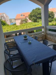 a blue table and chairs on a balcony at APARTMANI KATJA in Stara Novalja