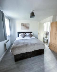 1 Schlafzimmer mit einem großen Bett und einem Badezimmer in der Unterkunft Spacious 6 Bedroom House Near City Centre in Birmingham