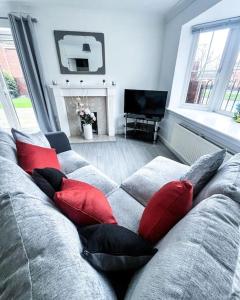 a living room with a couch with red pillows at Spacious 6 Bedroom House Near City Centre in Birmingham