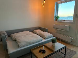 a bed in a room with a table and a window at Modern seaview house Ilulissat in Ilulissat