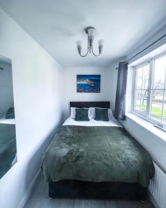 ein Schlafzimmer mit einem großen Bett und einer grünen Decke in der Unterkunft Spacious 6 Bedroom House Near City Centre in Birmingham