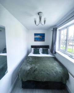 a bedroom with a large bed with a green blanket at Spacious 6 Bedroom House Near City Centre in Birmingham