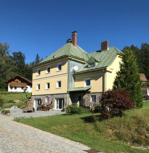 a large white house with a green roof at Das Alte Forsthaus Spiegelhütte in Lindberg