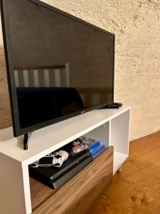 a flat screen tv on a white entertainment center at Maison Opéra in Bari