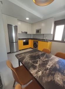 a kitchen with yellow and white cabinets and a table and chairs at Granada Home Center in Granada