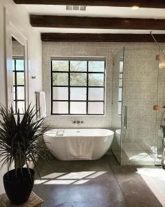 een grote badkamer met een bad en een potplant bij Luxury king suite downtown w lush garden terrace in Tucson