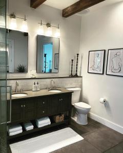 een badkamer met 2 wastafels, een toilet en een spiegel bij Luxury king suite downtown w lush garden terrace in Tucson