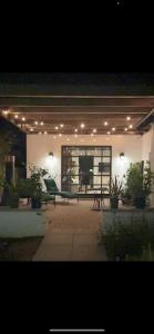 een patio met een tafel, stoelen en verlichting bij Luxury king suite downtown w lush garden terrace in Tucson