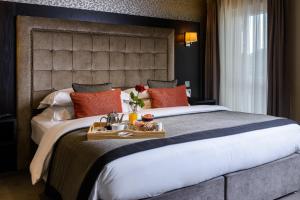 Un dormitorio con una cama grande y una bandeja de comida. en Killarney Oaks Hotel en Killarney