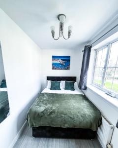 um quarto com uma cama num quarto com uma janela em Spacious 6 Bedroom House Near City Centre em Birmingham