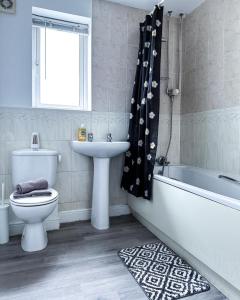 uma casa de banho com uma banheira, um WC e um lavatório. em Spacious 6 Bedroom House Near City Centre em Birmingham