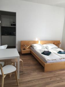 Cet appartement comprend une chambre avec un lit et une table ainsi qu'une cuisine. dans l'établissement Penzion nad Bankou, à Košice