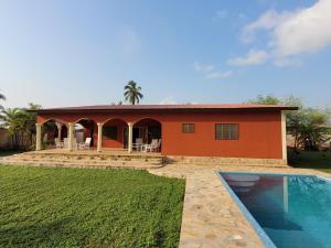a house with a swimming pool in front of it at La Belle Vie Là de Ouidah in Ouidah