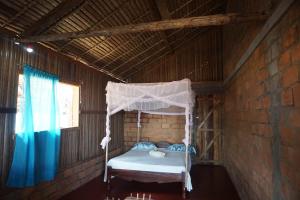 a bedroom with a canopy bed in a brick wall at Chez Antonio in Ampasimena