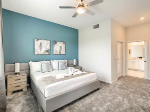 - une chambre avec un grand lit et un mur bleu dans l'établissement Beautiful 2BR with Waterpark & Private Game Room, à Kissimmee