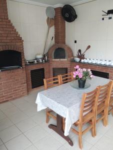 comedor con mesa y horno de ladrillo en Piscina 6 QUARTO 300m PRAIA jardim churrasqueira 16 PESSOAS garagem 3 carros Monitoramento 24 horas Mesa de sinuca, en Itanhaém