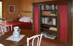 ein Schlafzimmer mit einem Bett und einem Tisch mit einer Vase in der Unterkunft 4 Bedroom Stunning Home In Louvie-juzon in Louvie Juzon