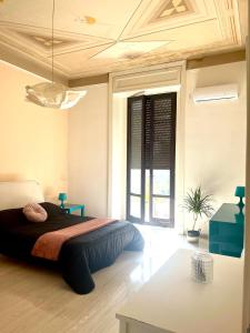 a bedroom with a bed and a large window at Deodato Guest House in Catania