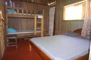 a bedroom with two bunk beds and a window at Chez Antonio in Ampasimena