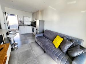 a gray couch with yellow pillows in a kitchen at Ocean View Villa - Ground level in West Point