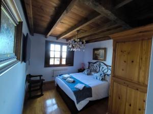 een slaapkamer met een bed en een kroonluchter bij QUINTES PLAYA in Villaviciosa