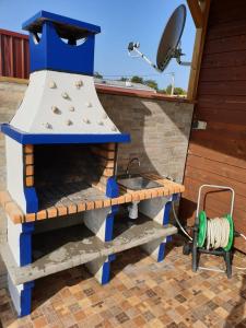 a outdoor kitchen with a stove and a sink at Sunset Milfontes in Vila Nova de Milfontes