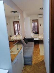 un salon avec un canapé et un miroir dans l'établissement Apartman Lala, à Vrnjačka Banja