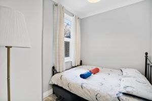 1 dormitorio con cama y ventana en 7 Bedroom house with Garden, en Londres