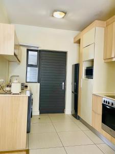 a kitchen with a black garage door in a kitchen at 2 Bedroom 2 Bathroom Apartment in Sandton in Johannesburg