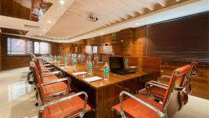 une salle de conférence avec une grande table, un ordinateur portable et des chaises dans l'établissement Airport Hotel Ramhan Palace Mahipalpur, à New Delhi