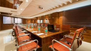 a conference room with a long table with a laptop and chairs at Airport Hotel Ramhan Palace Mahipalpur in New Delhi
