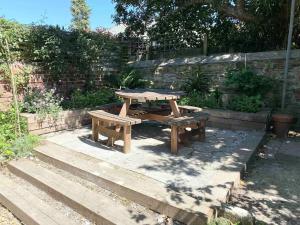 a picnic table and benches in a garden at Bright & Spacious Edwardian Townhouse with Garden in Truro