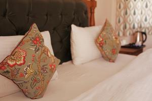 two pillows sitting on top of a bed at KothiPushkar in Pushkar