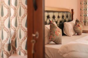 a bedroom with a bed with a black headboard and pillows at KothiPushkar in Pushkar