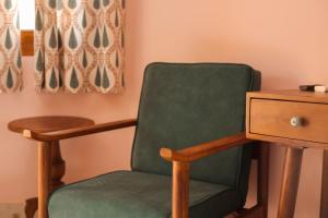 a green chair sitting next to a wooden desk at KothiPushkar in Pushkar