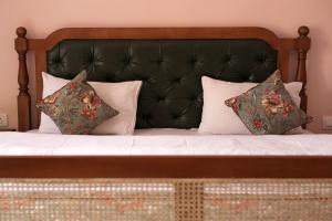 Bett mit schwarzem Kopfteil und Kissen in der Unterkunft KothiPushkar in Pushkar