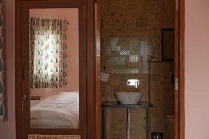 a bathroom with a sink and a bed in a room at KothiPushkar in Pushkar